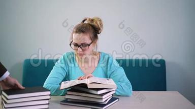 疲惫，愤怒，精疲力竭的学生低下头看一叠书。 你得读很多书。 很多工作。 闭嘴
